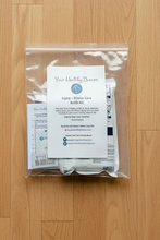 Load image into Gallery viewer, A packaged 'Your Healthy Dancer' Care Kit placed on a light dance studio floor.